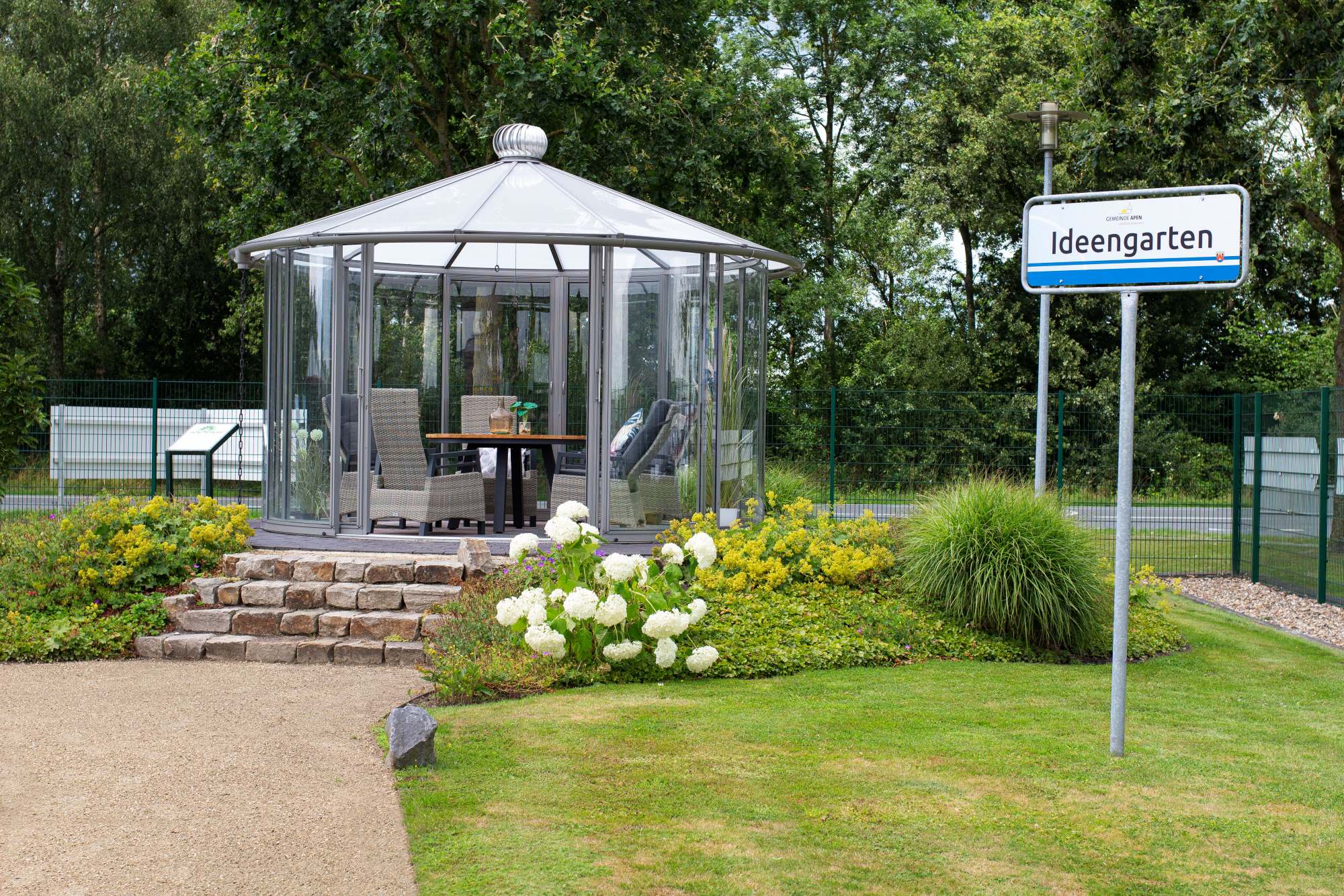 Glaspavillon mit Geflechtsesseln im Ideengarten in Apen